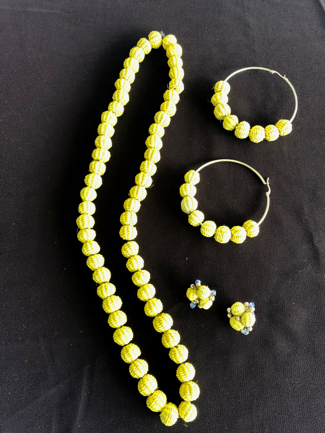 Kelly yellow paja toquilla necklace, large hoop post earrings and small rose earrings.