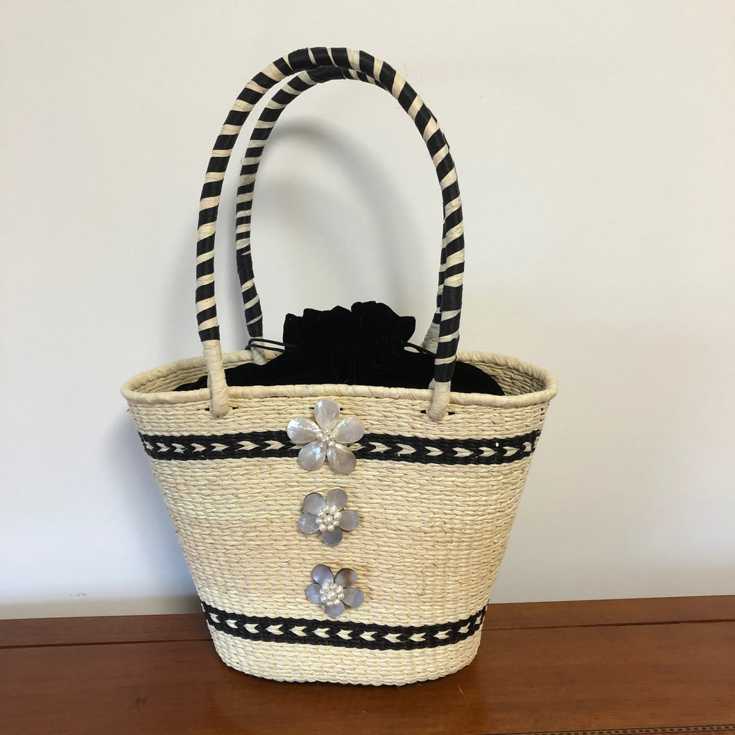 Amelia paja toquilla basket bag embellished with mother of pearl roses.